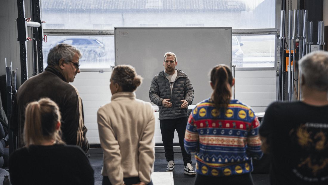 Des membres de tous âges écoutent le coach avant la séance